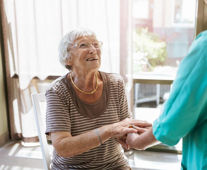 une femme âgée tenant la main d'une professionnelle de soins