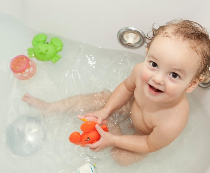 bébé en train de jouer dans une baignoire